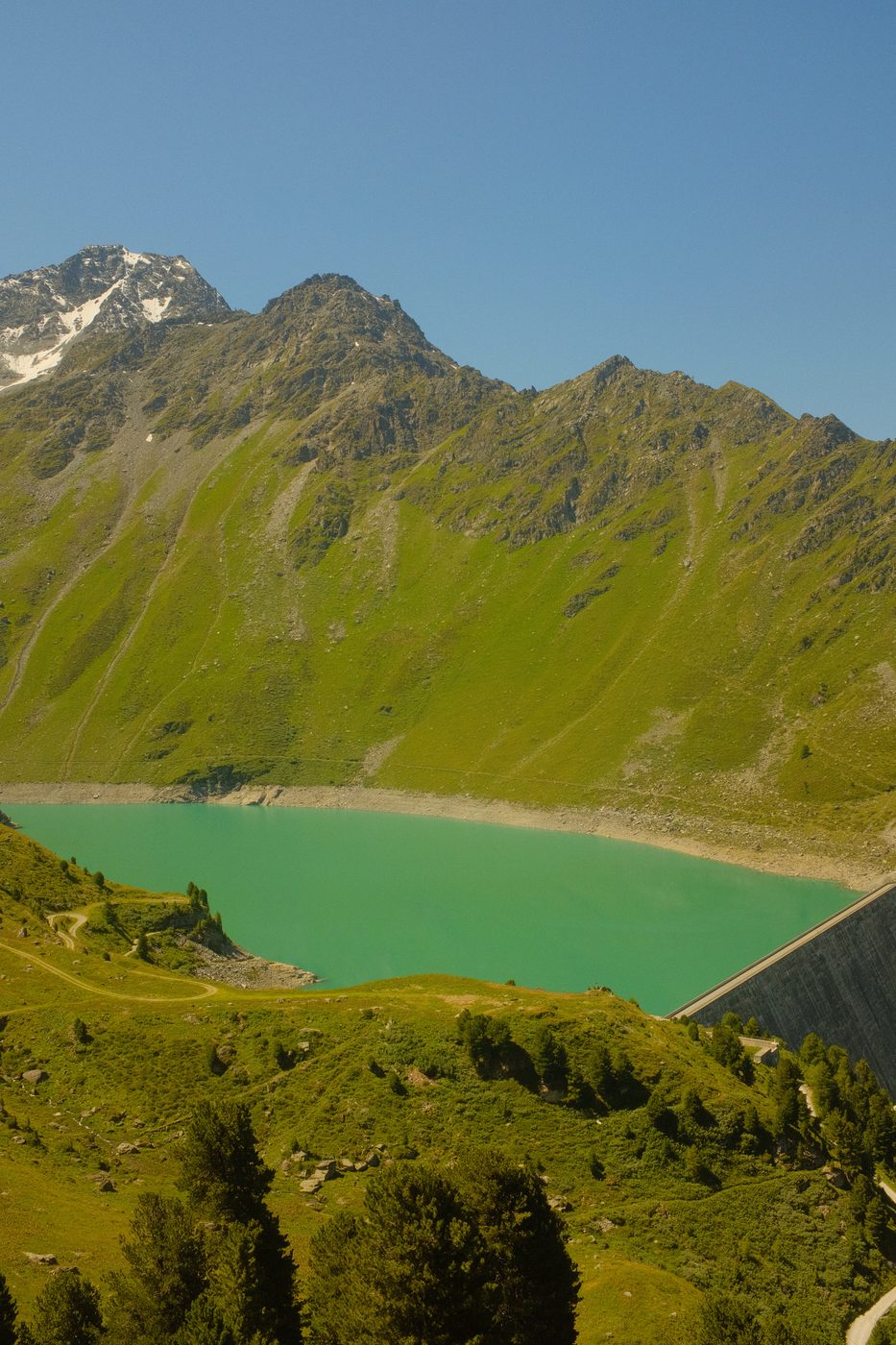 Turquoise alpine lake near Siviez, framed by snow-capped peaks